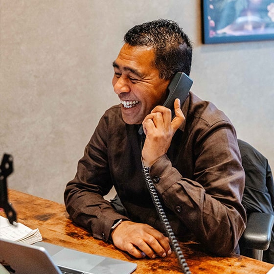 Makelaar lachend aan de telefoon