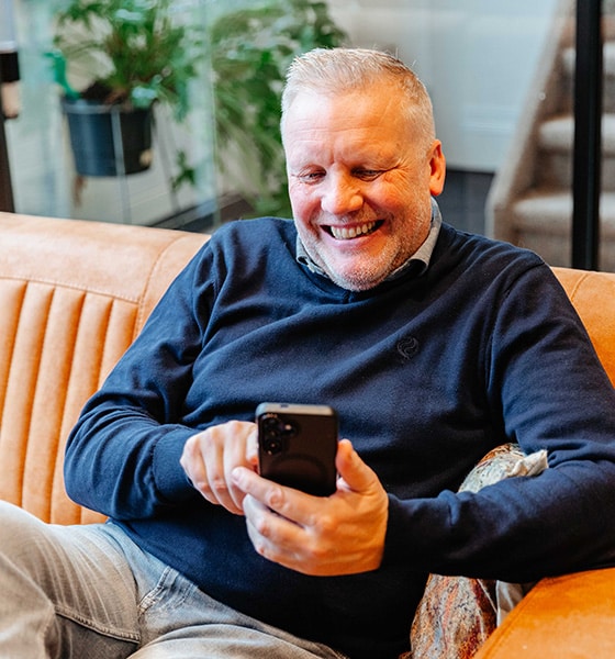 Makelaar lachend op zijn telefoon