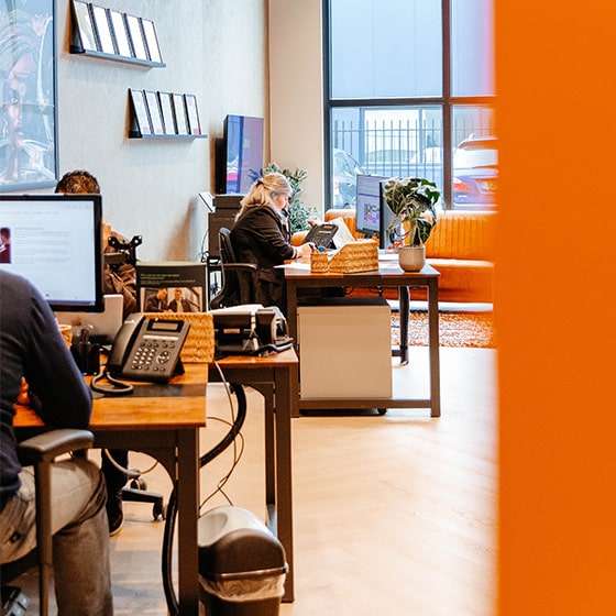 Medewerkers van het kantoor aan het werk achter hun bureau