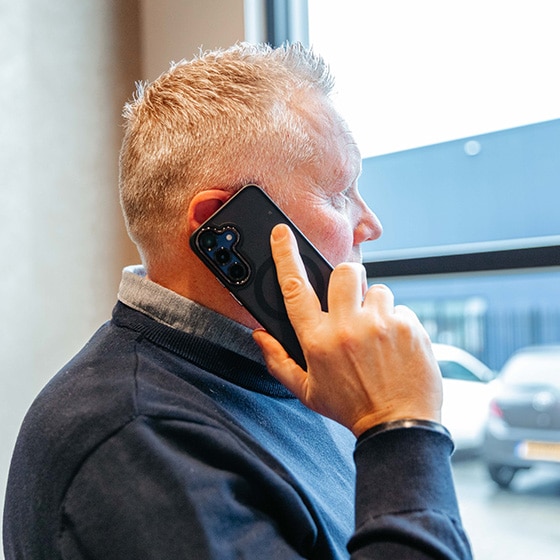 Makelaar aan de lijn terwijl hij naar buiten kijkt